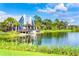 Exterior view of a beautiful community clubhouse by the lake with stunning landscaping and a tranquil ambiance at 4127 Broad Porch Run, Land O Lakes, FL 34638