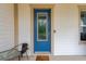 Charming blue front door with glass panel, complemented by a welcome mat and patio set at 4127 Broad Porch Run, Land O Lakes, FL 34638