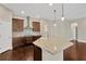 Stylish kitchen featuring an island with stone countertop, stainless hood, and dark wood cabinets at 4127 Broad Porch Run, Land O Lakes, FL 34638