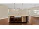 Gourmet kitchen island featuring a farmhouse sink, stainless steel dishwasher, and pendant lighting at 4127 Broad Porch Run, Land O Lakes, FL 34638