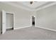 Neutral main bedroom with carpet, ceiling fan and adjoining bathroom at 4127 Broad Porch Run, Land O Lakes, FL 34638