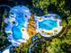 Aerial view showcasing resort-style pools and a wooden deck seating area at 4127 Broad Porch Run, Land O Lakes, FL 34638