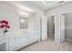 Bright bathroom featuring dual sinks, white cabinets and drawers and tile floors at 4135 Epic Cv, Land O Lakes, FL 34638