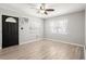 Bright living room with light wood floors, ceiling fan, and black front door at 4218 2Nd S Ave, St Petersburg, FL 33711