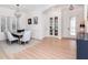 Open dining area with modern lighting, French doors, and views of the entryway with transom window at 4612 W Lowell Ave, Tampa, FL 33629