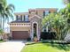 Charming two-story home featuring a beautiful stone entryway, well-manicured lawn, and mature palm trees at 4612 W Lowell Ave, Tampa, FL 33629