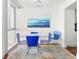 Dining area featuring a glass table and blue chairs, complemented by modern artwork and natural light at 470 3Rd S St # 814, St Petersburg, FL 33701