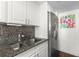 Renovated kitchen with granite countertops, stainless steel fridge, and modern faucet fixture at 470 3Rd S St # 814, St Petersburg, FL 33701
