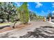 Gated community entrance with mature trees and lush landscaping on a bright sunny day at 5034 Blue Latan Ln, Tampa, FL 33610