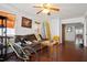 Cozy living room features a brown couch, bamboo shades, a surfboard, and dark laminate flooring at 505 Orange St, Palm Harbor, FL 34683