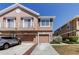 Charming townhome featuring a stone facade, private garages, and well-maintained landscaping under a bright, sunny sky at 565 52Nd N Ave, St Petersburg, FL 33703