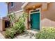 Inviting entryway featuring a vibrant teal door, lush greenery, and decorative plants creating a welcoming ambiance at 565 52Nd N Ave, St Petersburg, FL 33703