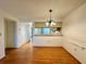 Open dining room with wood floors and a modern light fixture at 6125 113Th St # 505, Seminole, FL 33772