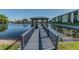 View of the community dock and gazebo over a reflective pond on a clear day at 6125 113Th St # 505, Seminole, FL 33772
