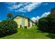 Condo exterior featuring yellow siding, green trim, and lush landscaping under a blue sky at 6125 113Th St # 505, Seminole, FL 33772