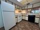 Functional kitchen with white appliances, light wood cabinets, and vinyl flooring at 6125 113Th St # 505, Seminole, FL 33772