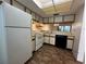 Functional kitchen with white appliances, light wood cabinets, and vinyl flooring at 6125 113Th St # 505, Seminole, FL 33772