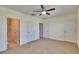 Spacious bedroom with a ceiling fan, carpet, and multiple closets and bathroom entryways at 708 Barclay Wood Dr, Ruskin, FL 33570