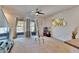 Spacious living room with ceiling fan, sliding glass doors, and neutral carpet at 708 Barclay Wood Dr, Ruskin, FL 33570