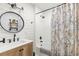 Beautiful bathroom featuring a wood vanity, shiplap wall, round mirror, and stylish patterned shower curtain at 8236 36Th N Ave, St Petersburg, FL 33710