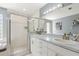 Bright bathroom with double sinks, stylish vanity, and a glass-enclosed shower with pebble flooring at 8236 36Th N Ave, St Petersburg, FL 33710
