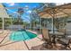 Outdoor pool and patio area with dining set and manicured landscaping at 8236 36Th N Ave, St Petersburg, FL 33710