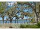 Scenic water view framed by lush trees and a charming white picket fence at 8236 36Th N Ave, St Petersburg, FL 33710