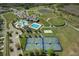 Wide aerial shot showing community amenities, including pools, a clubhouse, tennis and basketball courts, and lush landscaping at 8780 Flourish Dr, Land O Lakes, FL 34637