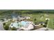 Aerial view of the community clubhouse, pools, playground, and well-maintained green spaces at 8780 Flourish Dr, Land O Lakes, FL 34637