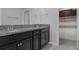 Bathroom with dark cabinets, double sink, granite countertop and a shower with modern curtain at 8780 Flourish Dr, Land O Lakes, FL 34637