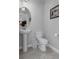 This bathroom features a pedestal sink, tile floors and a white toilet at 8780 Flourish Dr, Land O Lakes, FL 34637