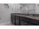 Bathroom with dark cabinets, double sink, granite countertop and mirror at 8780 Flourish Dr, Land O Lakes, FL 34637