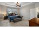 Bright bedroom features a tray ceiling, large windows, and a decorative chandelier at 8780 Flourish Dr, Land O Lakes, FL 34637