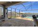 Screened-in lanai with a seating area, pool, and water view at 8780 Flourish Dr, Land O Lakes, FL 34637