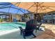 Relaxing screened-in pool area with lounge chairs, umbrella and clear blue water, perfect for a refreshing swim at 8780 Flourish Dr, Land O Lakes, FL 34637