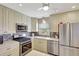 Bright kitchen features stainless steel appliances, white cabinets, modern backsplash and countertops at 9950 62Nd N Ter # 319, St Petersburg, FL 33708