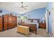 Spacious bedroom with neutral carpet, complemented by matching furniture with bedding, and bright blue walls at 7511 Terrace River Dr, Temple Terrace, FL 33637