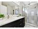 Bathroom featuring double sinks, white countertops, and a tiled shower at 10707 Avery Park Dr, Riverview, FL 33578