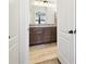 Well-appointed bathroom featuring a double vanity with granite countertop, wood-look tile flooring, and ample lighting at 11141 Spring Point Cir, Riverview, FL 33579