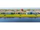 Beautiful backyard with a pond view, lush green lawn, and colorful houses nearby at 11422 Captiva Kay Dr, Riverview, FL 33569