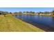 Scenic backyard with waterfront views of a tranquil pond and green lawn at 11422 Captiva Kay Dr, Riverview, FL 33569