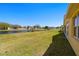 Spacious backyard with a tranquil pond view, lush green lawn, and partial view of the house at 11422 Captiva Kay Dr, Riverview, FL 33569
