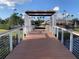 Wooden bridge with white railings and an overhead trellis leading to pool area at 11422 Captiva Kay Dr, Riverview, FL 33569