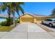 Charming yellow home with a spacious driveway, two-car garage, and tidy landscaping at 11422 Captiva Kay Dr, Riverview, FL 33569