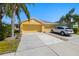 Charming yellow home featuring a spacious driveway and well-manicured landscaping at 11422 Captiva Kay Dr, Riverview, FL 33569