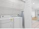 Bright laundry room with white washer, dryer, wire shelving, and ironing board at 11422 Captiva Kay Dr, Riverview, FL 33569