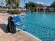 Large community pool with a chair lift for accessibility, surrounded by palm trees and lounge area at 11422 Captiva Kay Dr, Riverview, FL 33569