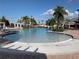 Expansive view of the pool area with lounge chairs, landscaping, and a nearby building at 11422 Captiva Kay Dr, Riverview, FL 33569