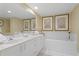 Bright bathroom with a soaking tub, double vanity, and decorative artwork at 1180 Gulf Blvd # 1604, Clearwater Beach, FL 33767