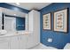 Bathroom with blue wallpaper, white cabinets, sink, and framed artwork of fish at 1180 Gulf Blvd # 1604, Clearwater Beach, FL 33767
